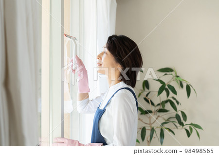 middle woman cleaning windows middle woman cleaning windows 98498565