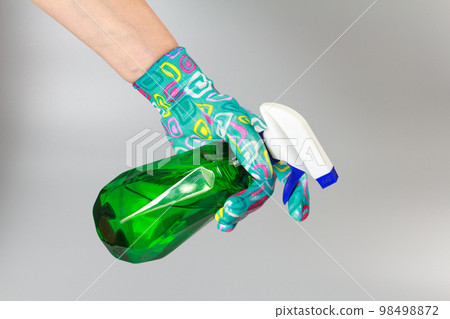 Woman's hand with a pressure sprayer on gray background. 98498872