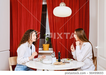 Two women having meal together and talking 98499693