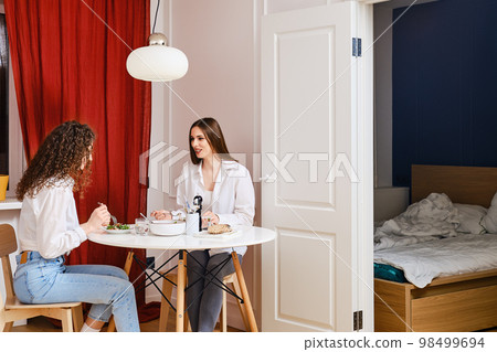 Woman spent night at friend's house and they have breakfast in morning together 98499694