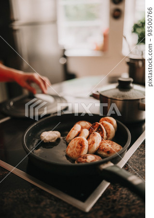 Cottage cheese pancakes for breakfast in frying pan on kitchen background 98500766