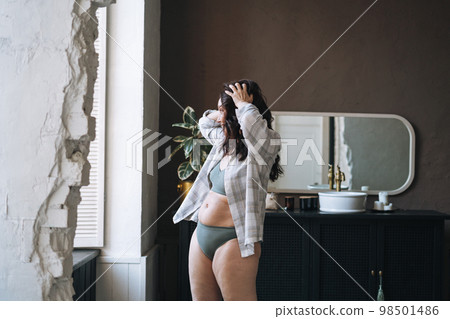 Self loving plus size middle aged woman in underwear in bathroom at home 98501486