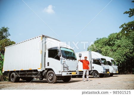Asian delivery man driver in red uniform standing near truck 98501525