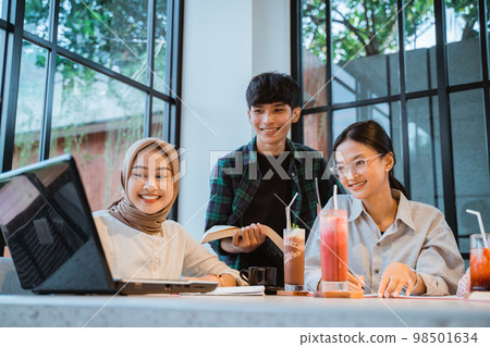 three young Asian people looking at a laptop together 98501634