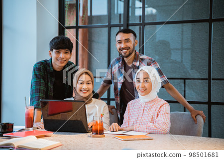 four young Asian people smiling in a cafe 98501681