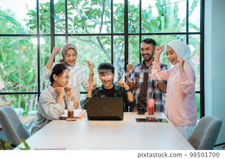 some young people are excited when looking at a laptop some young people are excited when looking at a laptop 98501700