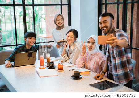 five young asian people smiling taking selfie using cell phone five young asian people smiling taking selfie using cell phone 98501753