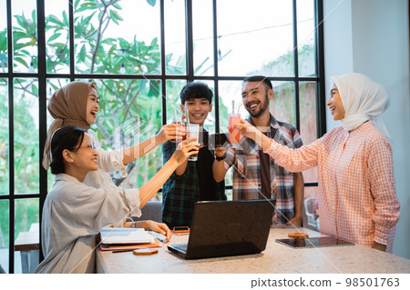 young asian people smiling with lets toast gesture while gathering 98501763