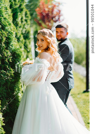 the groom leads the bride by the hand along the path. the groom leads the bride by the hand along the path. 98501844