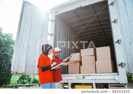 two forwarders checking boxes of delivery packages in a cargo two forwarders checking boxes of delivery packages in a cargo 98501845