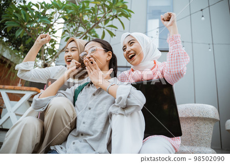 happiness of three excited girls with their hands clenched up 98502090