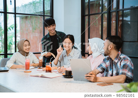 Asian young people doing homework together in cafe 98502101