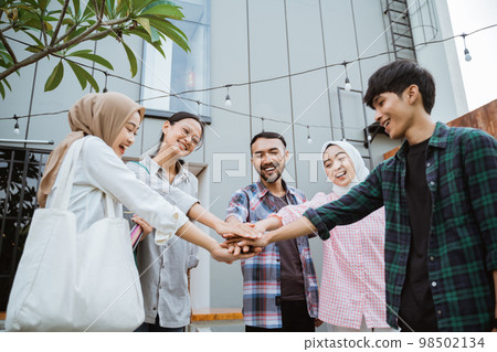 asian students with united hand gesture while together hanging out asian students with united hand gesture while together hanging out 98502134