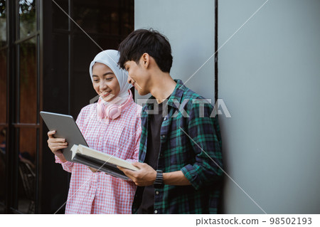 Muslim girl in hijab using a pad with a boy 98502193