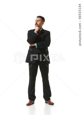 Businessman in a suit standing with thoughtful serious face over white studio background. Working day. Concept of business, career, innovations, ad 98503184
