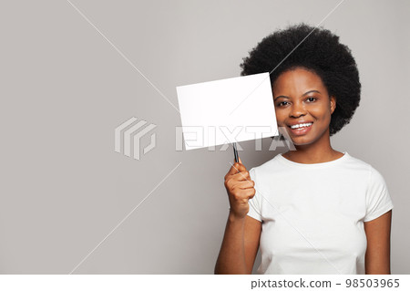 Pretty model woman with white empty paper board banner on gray background 98503965