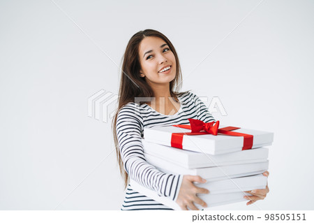 Portrait of young smiling asian woman with stack of gift boxes in hands on white background isolated Portrait of young smiling asian woman with stack of gift boxes in hands on white background isolated 98505151