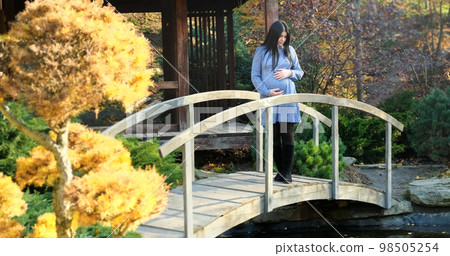 Pregnant mother walk in autumn park nature in morning. Beautiful pregnant woman walking on natural background. Expecting baby. Healthy, active relaxing pregnancy. motherhood happiness Pregnant mother walk in autumn park nature in morning. Beautiful pregnant woman walking on natural background. Expecting baby. Healthy, active relaxing pregnancy. motherhood happiness 98505254