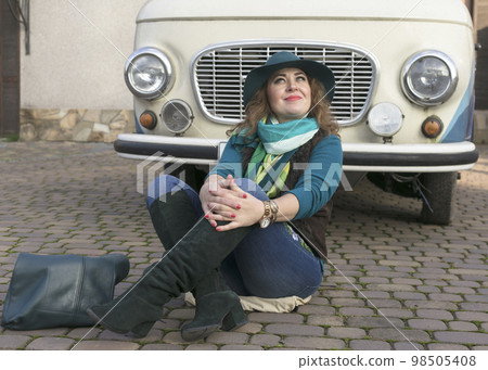 Woman next to retro minivan Woman next to retro minivan 98505408