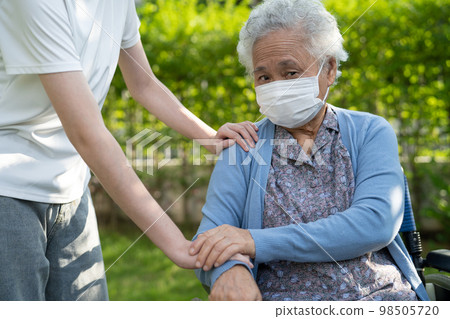 Caregiver help and care Asian senior or elderly old lady woman patient sitting on wheelchair in park, healthy strong medical concept. Caregiver help and care Asian senior or elderly old lady woman patient sitting on wheelchair in park, healthy strong medical concept. 98505720