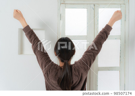 A woman who wakes up in the morning and stretches 98507174