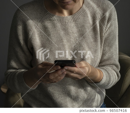 Closeup image of a beautiful young asian woman holding and using mobile phone Closeup image of a beautiful young asian woman holding and using mobile phone 98507416