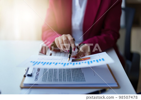 Close up of Asian Business woman working at home office and analyze financial report document. Accounting and Finance concept Close up of Asian Business woman working at home office and analyze financial report document. Accounting and Finance concept 98507478