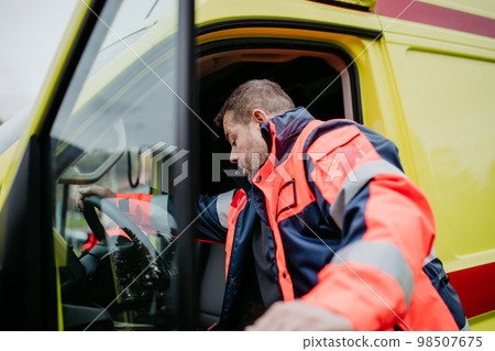Rescuer getting in to ambulance car, preparing for rescue operation. Rescuer getting in to ambulance car, preparing for rescue operation. 98507675