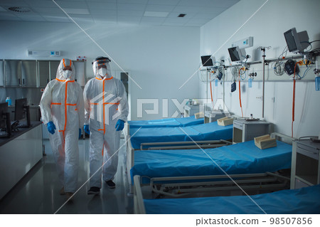 Doctors in protective coveralls in hospital room, infectious disease concept. Doctors in protective coveralls in hospital room, infectious disease concept. 98507856