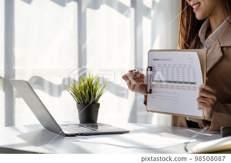 Asian Business woman working at home office and analyze financial report document. Accounting and Finance concept Asian Business woman working at home office and analyze financial report document. Accounting and Finance concept 98508087