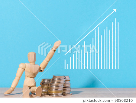 Wooden mannequin and graph with growing indicators, high income. Wooden mannequin and graph with growing indicators, high income. 98508210