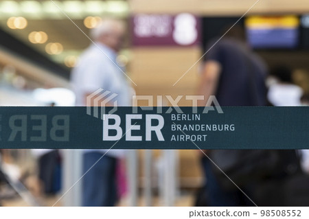 Close-up detail view of BER code Berlin Brandenburg airport logo security barrier tape divider ribbon inside new terminal building. German capital IATA sign. Trade union strike flight cancellation 98508552