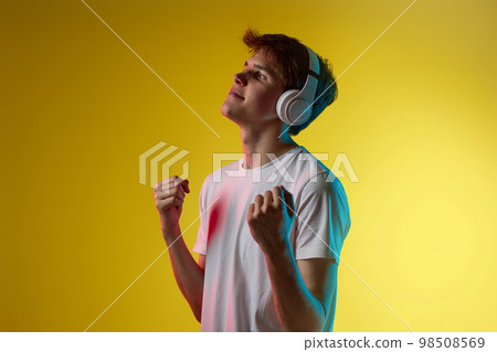 Young man listening to music with headphones 98508569