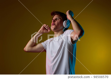 Young man listening to music with headphones 98508570