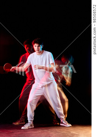 young man playing table tennis in mixed neon light 98508572
