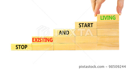 Stop existing start living symbol. Concept words Stop existing and start living on wooden blocks. Beautiful white table white background. Business Stop existing start living concept. Copy space. 98509244