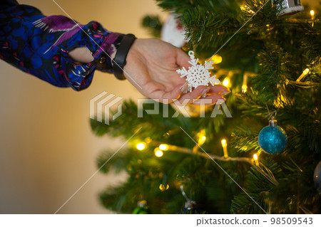 Close up of girls hand holding a decorative snowflake for a fir tree 98509543