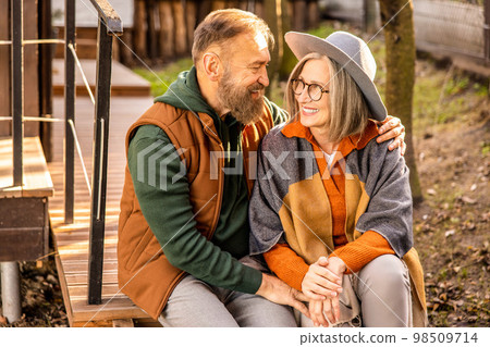 Man and woman sitting close and looking in love Man and woman sitting close and looking in love 98509714