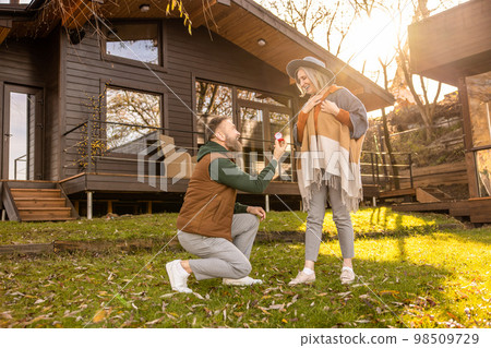 Man making a proposal to his beloved and giving an engagement ring Man making a proposal to his beloved and giving an engagement ring 98509729