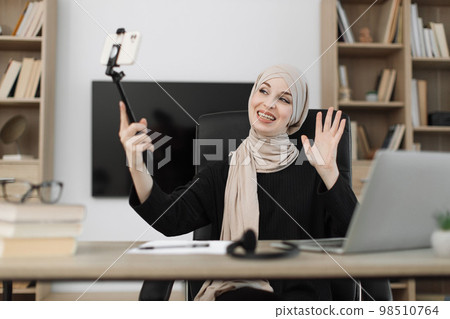 Female blogger sitting at home and doing live stream. 98510764