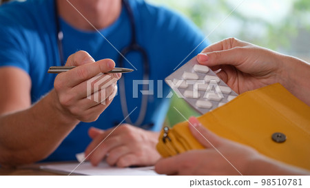 Pharmacist explains prescription to client with medicinal pills. 98510781