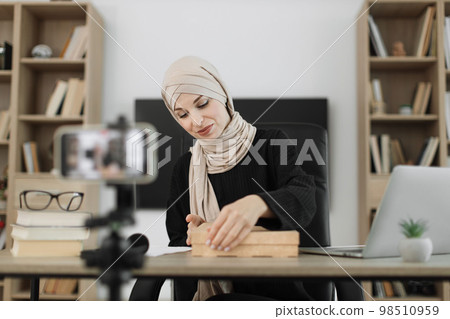 Arab woman using smart phone camera for creating content. 98510959
