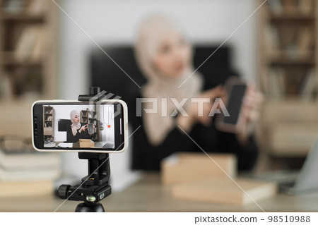 Focus on smart phone screen, pleasant arab woman filming video on modern phone camera Focus on smart phone screen, pleasant arab woman filming video on modern phone camera 98510988
