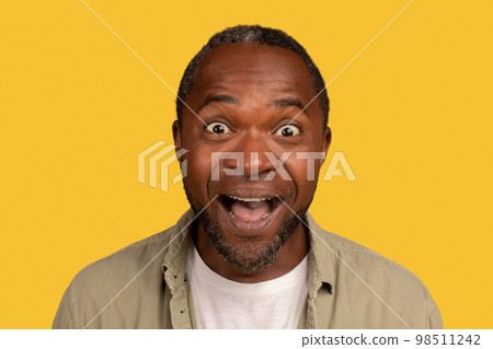 Portrait of glad surprised african american middle aged man with open mouth, looking at camera Portrait of glad surprised african american middle aged man with open mouth, looking at camera 98511242