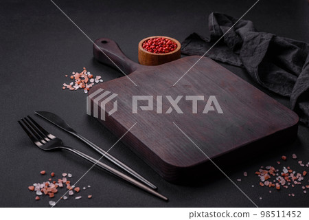 Empty wooden cutting board with spices and herbs Empty wooden cutting board with spices and herbs 98511452
