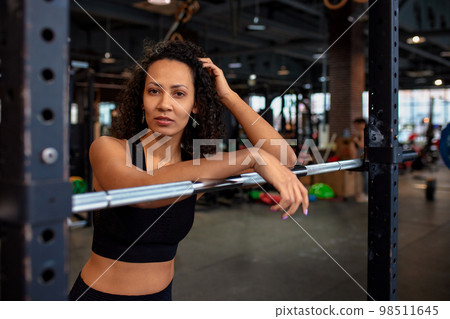 Athletic african american woman in crossfit gym close up smiling leaning on a barbell. Athletic african american woman in crossfit gym close up smiling leaning on a barbell. 98511645
