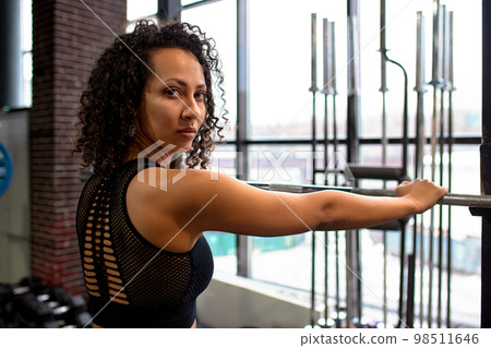 Athletic african american woman in crossfit gym close up smiling leaning on a barbell. Athletic african american woman in crossfit gym close up smiling leaning on a barbell. 98511646
