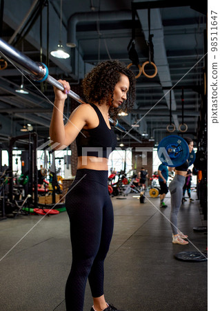 Athletic african american woman getting ready to do barbell squat in crossfit gym, hard workout. Athletic african american woman getting ready to do barbell squat in crossfit gym, hard workout. 98511647