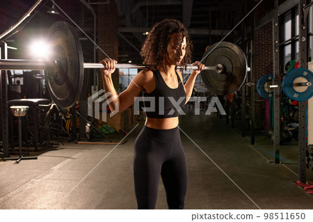 Athletic african american woman getting ready to do barbell squat in crossfit gym, hard workout. Athletic african american woman getting ready to do barbell squat in crossfit gym, hard workout. 98511650