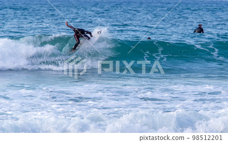 Handsome young rider in a blue suit - riding a wave in Tel Aviv in sunny Israel 98512201